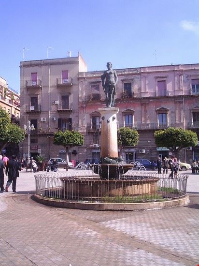  La fontana di piazza Umberto I, alle spalle la facciata del palazzo Rosso. Valerio De Carlo  - Dominio pubblico Valerio De Carlo 
