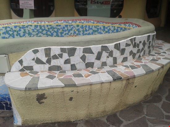 Rosignano Marittimo esaltata dall’innesto di colori allegri composti da vari frammenti di ceramiche (vedi foto) mostrando la ricostruzione di un fondale marino dove a pelo di acqua di mare sorge un sole rosso (vedi foto). Questa seduta si snoda esattamente come nel Parc Guell ed inizia con un insieme di marmi bianchi, neri e graniti rossi e arancio quasi a voler sottolineare che in Toscana sulle Alpi Apuane vive il Marmo che tanta espressione artistica ha regalato in tutta Italia.  