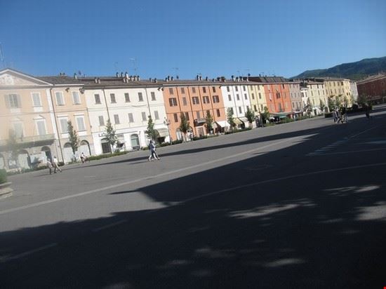  I colori della piazza Cristoforo Colombo a Bettola ( Val Nure - Piacenza ) .
Il primo edificio , a sinistra nell' immagine , è il comune .
Immagini della Beata Vergine della Quercia , il giorno della festa della patrona della Val Nure ( la prima domenica di settembre ) , esposti dalle finestre e negli alberi .  