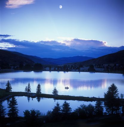 Mountain moonset over lake