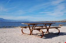 Old picnic table on beach along lake
