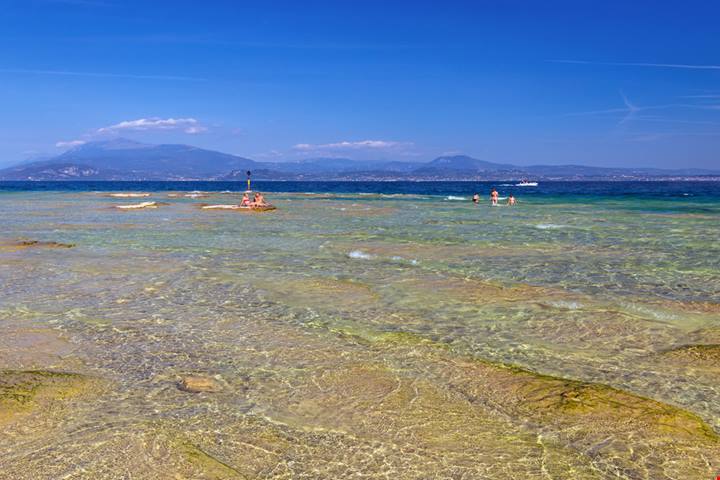Anche in Lombardia puoi rinfrescarti con un bagno in un luogo meraviglioso: questi spiaggiotti sul Lago di Garda non ri faranno rimpiangere il mare