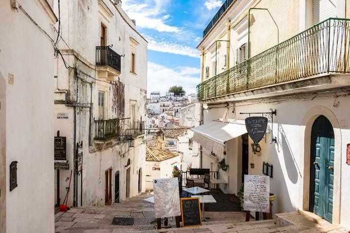 In Puglia esiste una città bianca sospesa tra cielo e mare: la sua grotta sacra attira pellegrini da tutto il mondo