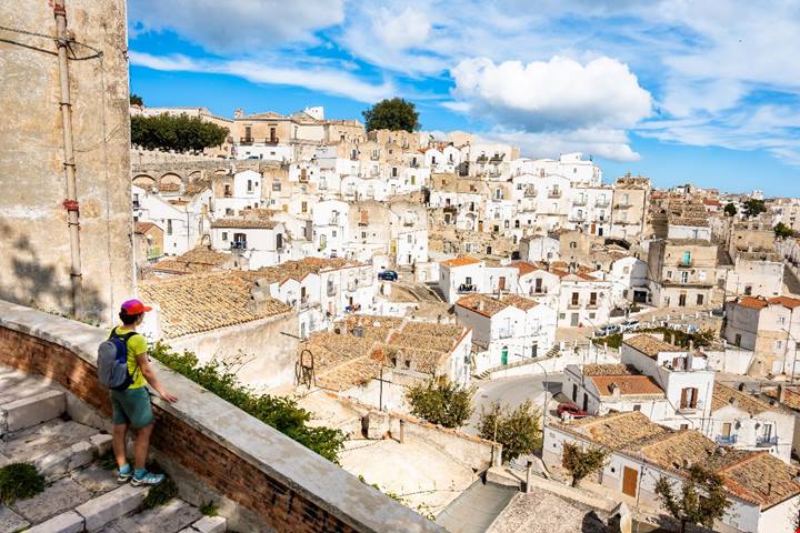 In Puglia esiste una città bianca sospesa tra cielo e mare: la sua grotta sacra attira pellegrini da tutto il mondo