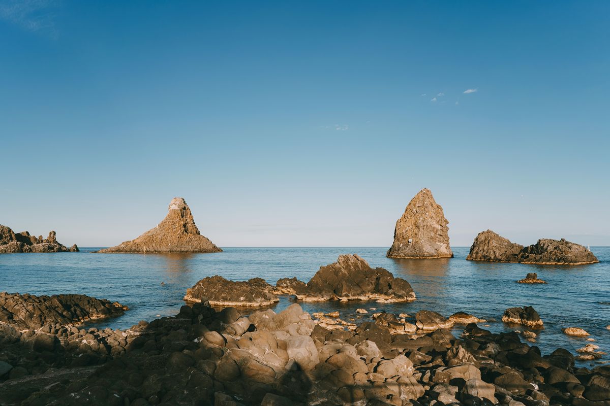 Qui l'alba è uno spettacolo... gigante: vicino Catania c'è la Riviera che incanta con i suoi faraglioni sospesi in acqua