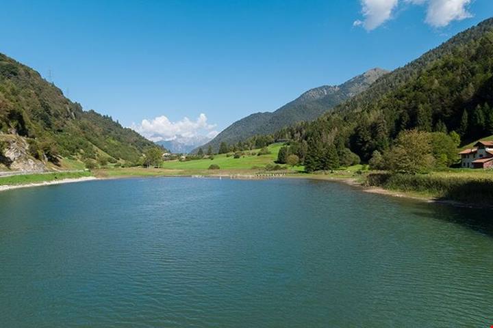 Incastonato tra boschi e prati del Trentino, questo specchio d'acqua Bandiera Blu è una perla di relax