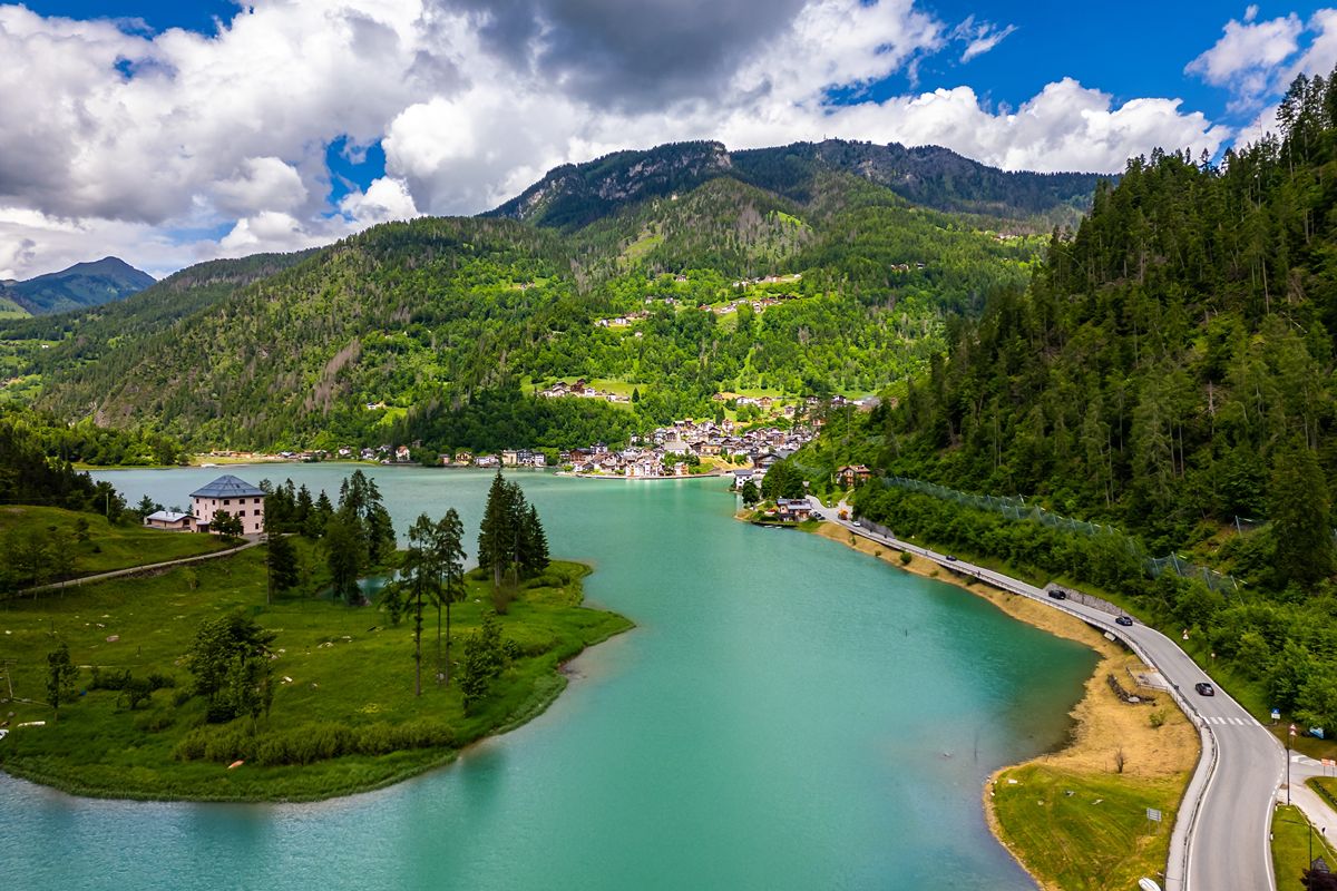 Il villaggio alpino dove il lago riflette le case e la montagna sembra entrare nel paese