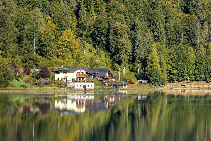 Il villaggio alpino dove il lago riflette le case e la montagna sembra entrare nel paese