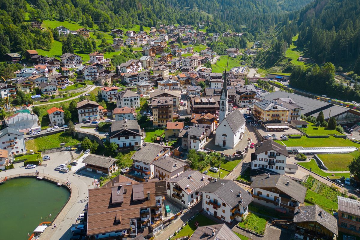 Il villaggio alpino dove il lago riflette le case e la montagna sembra entrare nel paese