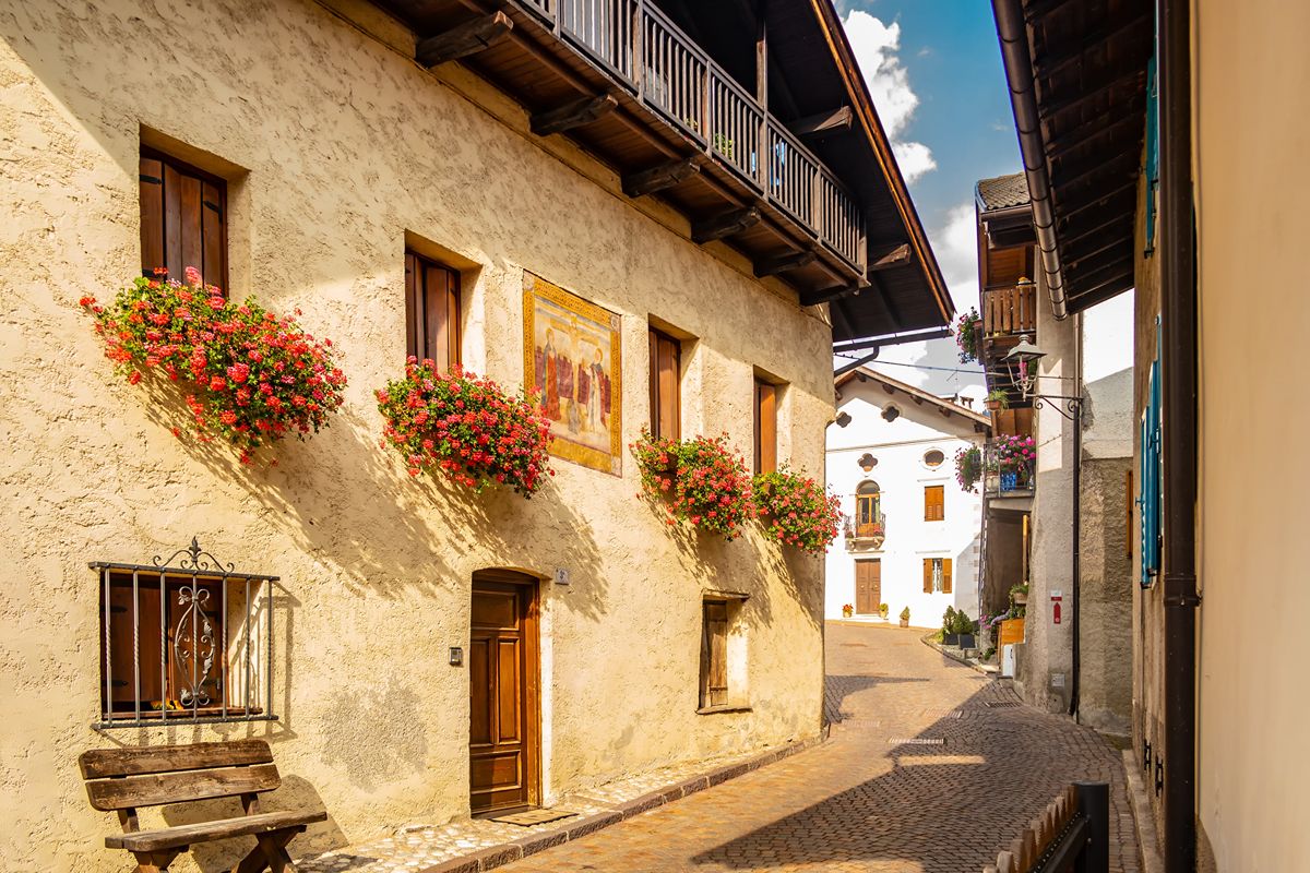 Tra le Dolomiti, un borgo alpino trasforma le tradizionali cataste di legna in originali opere d'arte, creando un percorso tra vicoli, storia e tradizioni.