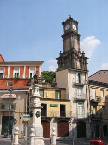  In evidenza la torre dell'orologio che spunta da dietro le case del centro storico della città, da notare anche la statua del "Reuccio"  