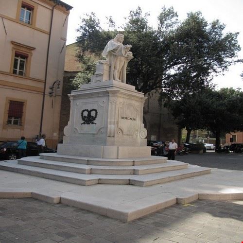  Il monumento a Giambattista Morgagni si trova nella piazza omonima . Nell' immagine si vede anche la Chiesa di San Pellegrino .  